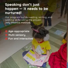 A child sits comfortably on the floor, absorbed in a picture book. Our age-appropriate, multi-sensory phonics program is designed to be fun and interactive, nurturing a natural love for reading.