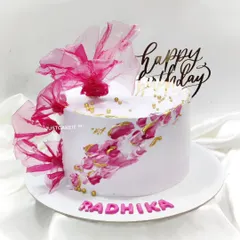 An abstract cake with a beautiful splash of pink and gold. The design is finished with a dramatic, edible rice paper sail.