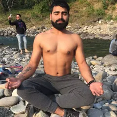 Meditating on a bed of river stones. Connecting with nature during mindfulness practice can deepen the experience, helping to achieve a state of peace that comes from understanding and acceptance.