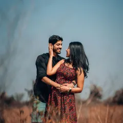 An intimate portrait of a couple in a sun-drenched field of tall grass. We use natural elements to frame our subjects, creating a soft, romantic, and cinematic feel for your pre-wedding album.