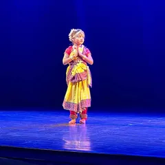 A young Bharatnatyam dancer in a moment of quiet devotion on stage. We teach our students that dance is not just movement but also a form of spiritual expression.