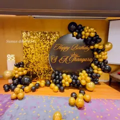 This was a grand 95th birthday celebration. I used a gold sequin shimmer wall for a glamorous photo backdrop, paired with a custom black circular sign. The black and gold balloon garland and light-up marquee number '95' complete this elegant party setup.