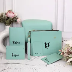 A full view of the personalized travel kit in a cool mint green. This set includes a passport holder, luggage tag, card holder, and pouches of different sizes, all customized with the name "Karan" for a cohesive look.