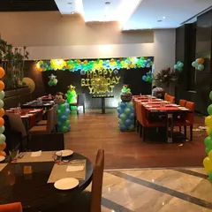 For this jungle themed birthday, we transformed a section of a restaurant with fun decor. The setup included monkey-topped balloon pillars and a backdrop with a personalized 'Happy Birthday' message, creating a playful atmosphere for the kids.