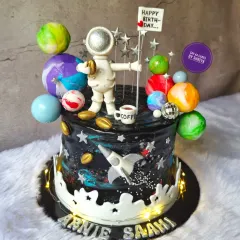 A cake for a dreamer who loves space and coffee. This galaxy-themed cake features a hand-painted cosmic design, edible planets, and a custom astronaut figurine holding a tiny coffee cup, blending two passions into one delicious creation.