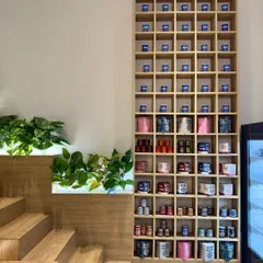 The merchandising unit at Beanly is a key brand identifier. This tall, grid-like shelf is visible from every corner of the cafe, showcasing the colorful product range and serving as a storage installation for personalized customer cups.