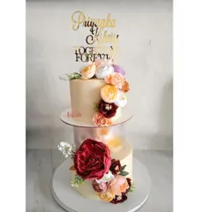 This elegant two-tier floral cake was for Priyanka and Kshitij's wedding. They loved the idea of a floating design, and I used a separator to create this beautiful effect. Topped with a custom gold acrylic topper, it featured two different flavors to satisfy all the guests.