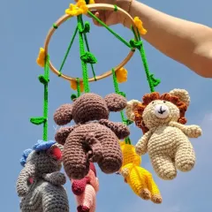 Bring the magic of the jungle to your nursery with this handmade animal mobile. Featuring a lion, elephant, and monkey, each little character contains a gentle rattle to softly engage and soothe your baby.