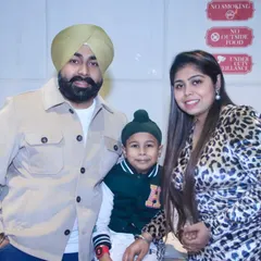 A portrait of a Sikh family. The parents pose with their young son, creating a beautiful family photograph that reflects their identity and togetherness.