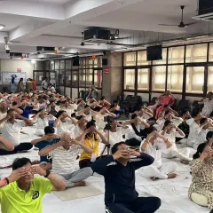 A large group practicing Bhramari Pranayama (Bee Breath) together. This powerful breathing technique is incredibly calming for the mind and is even more potent when practiced in a group.