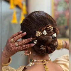 For the mother of the bride, I crafted this sophisticated twisted bun. It's a timeless and graceful updo, which I accented with small floral hairpins and gypsophila for a touch of royal elegance.