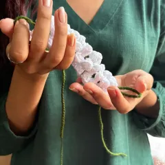 Holding the gajra so you can see the detail in each little crocheted flower. I use a soft cotton yarn to create this delicate, handcrafted hair accessory.