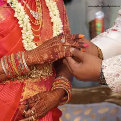 The moment of the ring exchange during an engagement ceremony. This close-up shot focuses on the hands, the intricate Mehndi, and the symbol of commitment.