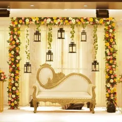 I love creating reception stages that feel both elegant and warm. Here, a classic white and gold chaise lounge is framed by colorful floral pillars and delicate hanging lanterns, creating a romantic and picture perfect setting for the happy couple.