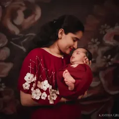 There is nothing more powerful than a mother's love. This studio portrait focuses on the tender bond between a mother and her newborn, using soft lighting against a floral backdrop to create a timeless, emotional photograph.