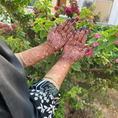 A gorgeous, fully developed henna stain on both hands and arms, set against a natural background. The deep color demonstrates the quality of my fresh, organic henna paste.