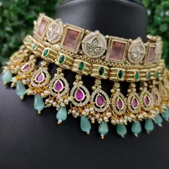 A detailed view of a modern pastel choker. This rental piece combines pink and green stones with mint-green bead drops for a fresh and contemporary bridal look.
