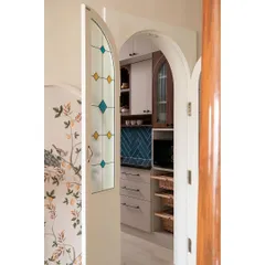To provide privacy for the open kitchen, I designed this beautiful arched door with stained glass panels. It adds to the home's traditional aesthetic while allowing light to pass through.
