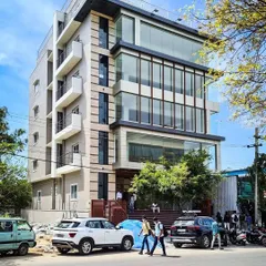 The completed commercial building for Mr. Shivaram in HSR Layout, a bustling commercial hub in Bangalore. This structure features a prominent multi-story glass facade, a signature element of our modern architectural style, designed to maximize natural light and create a strong street presence.