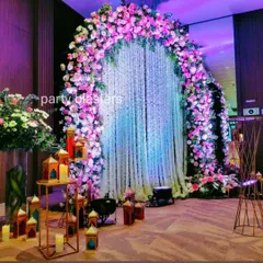A breathtaking floral arch makes for an unforgettable entrance or photo backdrop. This design uses a cascade of fresh flowers in pink and white, with a curtain of jasmine strings that adds a touch of fragrant elegance.