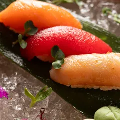 A macro close-up of three different types of nigiri. This detailed shot emphasizes the texture and freshness of the fish, key selling points for sushi.