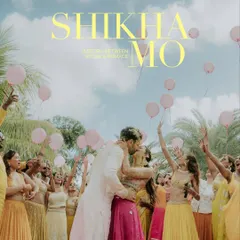 A celebratory moment from the Haldi in Mauritius, captured for Vogue India. The couple shares a kiss surrounded by friends and family releasing pink balloons, creating a vibrant and joyful scene.