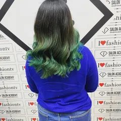 The final result of the green ombre hair coloring, beautifully styled into soft waves to showcase the seamless color blend achieved by our student.