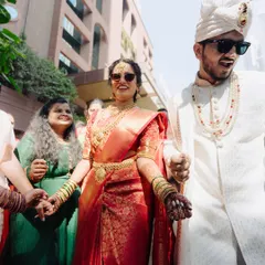 The bride's cool entrance with sunglasses adds a modern twist to her traditional South Indian look.