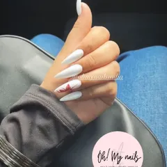 White for the win. This clean and striking look features long, sharp stiletto nails in a solid, opaque white, with a single accent nail featuring a red maple leaf.