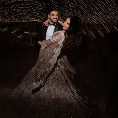 A magical moment under a tunnel of fairy lights. This shot captures the romance and fantasy of an engagement night, with the couple lost in a dance.