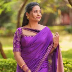 A beautiful outdoor shot highlighting the detailed beadwork and embroidery on the neckline and sleeves of this purple rental blouse.