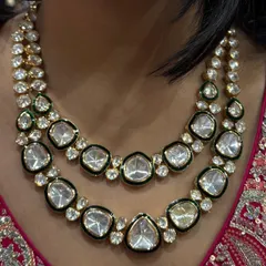 A stunning two-layer uncut polki necklace. The large, clear stones are set with a fine green meenakari border, creating a simple yet grand look.