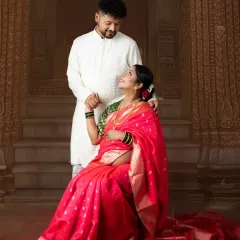 A beautiful moment between the couple, dressed in traditional attire. The rich pink saree and the classic setting create a portrait that is full of cultural pride.