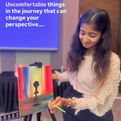 Me, painting a colorful abstract piece during a workshop. I often paint alongside my students to share the creative energy.