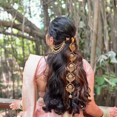 The hairstyle is just as important as the makeup. Here, you can see the intricate traditional hair accessories woven into her braid, completing the royal Maharashtrian bride aesthetic.