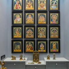 The spiritual center of this SNN Clermont home features a stunning Tanjore-inspired pooja wall, with a symmetrical arrangement of framed deities above a modern shaker-style console.