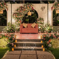 An aesthetic wedding dinner stage set in a lush garden. The pops of pink and romantic lighting create an elegant and magical atmosphere for an evening of celebration.