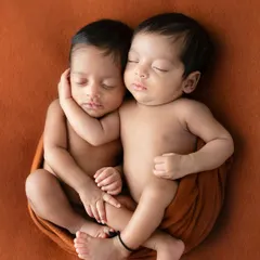 Two newborn twins, connected before birth. This portrait captures their magical bond as they rest together, their heartbeats in sync, just as they were in the womb.