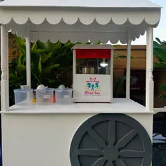 Our charming white wheeled cart, set up as a popcorn station. This versatile cart can be used for any of our live food services to match your event's style.