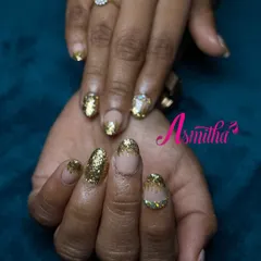 A close-up of the full-coverage gold glitter nails. This is a glamorous and celebratory look, ideal for brides or anyone attending a grand function.