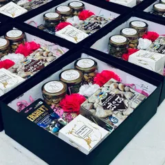 A look inside our wedding favor boxes. This one features a mix of traditional and modern treats, including a box of Nandini Dharwad Peda, jars of dry fruits, and Hershey's chocolates.