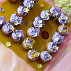 For a special birthday, I arranged these purple-frosted cupcakes into a heart shape. Each cupcake is decorated with small chocolate bars, edible hearts, and delicate sugar flowers.