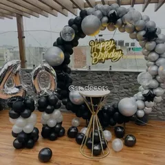 A sleek and modern 40th birthday rooftop decoration with a black and silver balloon ring and matching number balloons.