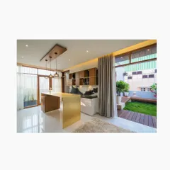 From our Athulyam project, this indoor entertainment area features a sleek, wafer-thin brushed brass bar counter. It is positioned to overlook an adjoining terrace, seamlessly connecting the indoor party space with the outdoor garden.