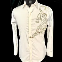 The 'ROAR' collection's white tiger shirt. The powerful, crouching tiger is embroidered in gold and silver thread, creating a design that is both fierce and elegant.