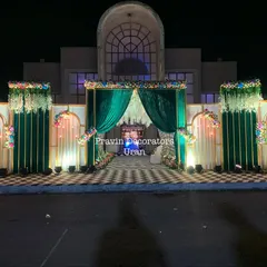 This elegant entrance structure combines rich emerald green drapes with white floral panels and a checkered floor. The design creates a sense of grandeur right at the entrance of the venue.