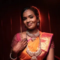 A lovely reception look with a bright orange and pink saree, paired with beautiful silver jewelry.
