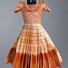 This charming kids' lehenga in peach and orange tones was created from a semi-Kanchi saree. I can create these custom outfits for children, offering a unique and traditional alternative to ready-made dresses.