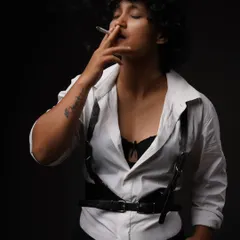 A moody, cinematic portrait from my 'Leather straps and Cigarettes' series. This demonstrates my conceptual work, using dramatic lighting and styling to tell a story.