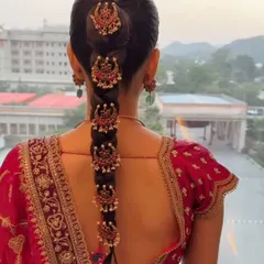 This South Indian temple jewelry braid is a work of art. I created a sleek, long braid and adorned it with traditional gold hairpieces for a groom's sister, giving her a regal and authentic look for the wedding ceremony.